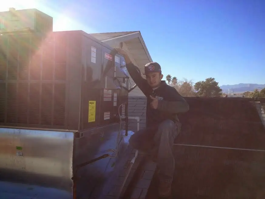 HVAC technician performing Air Duct Repair on a rooftop unit in Victoria